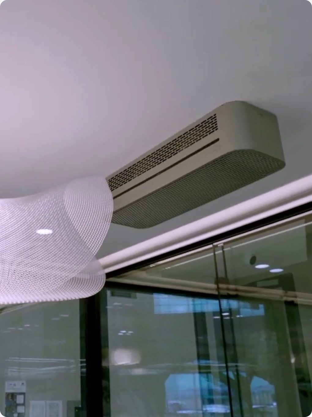 HIVE mounted on an office ceiling above a glass partition